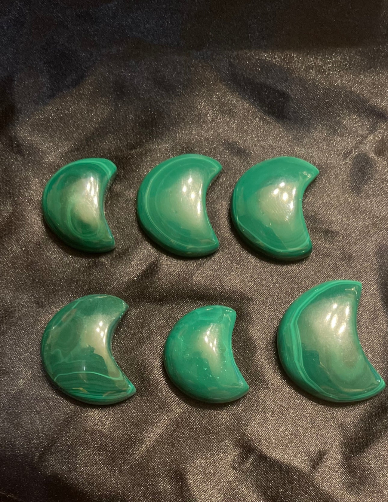Malachite Moon carved crystal, held in hand for scale