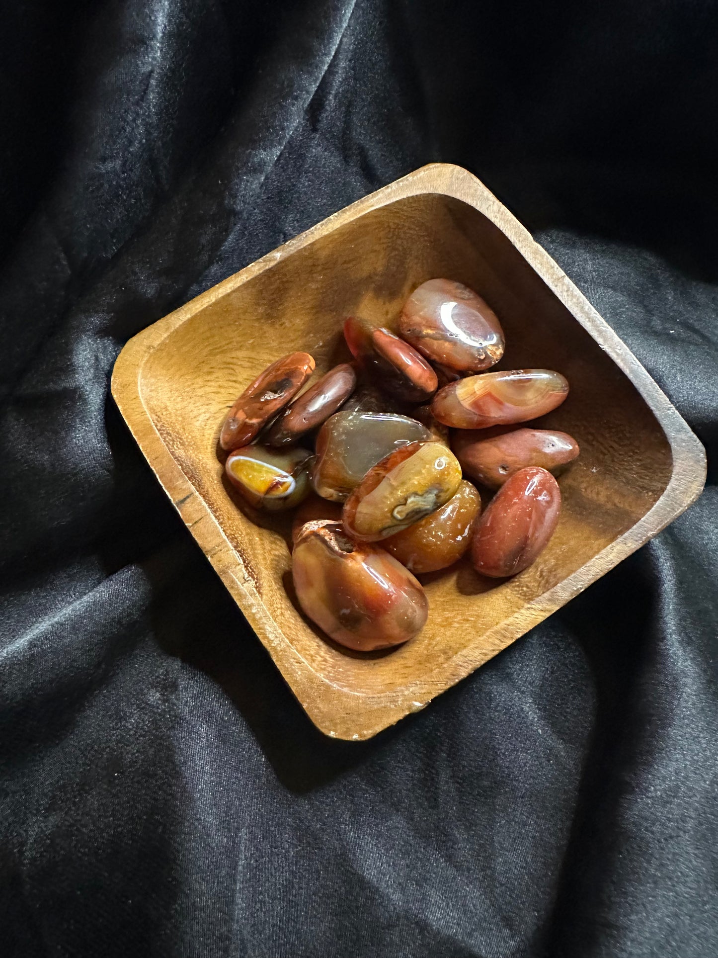 Carnelian tumbled stone, held in hand for scale