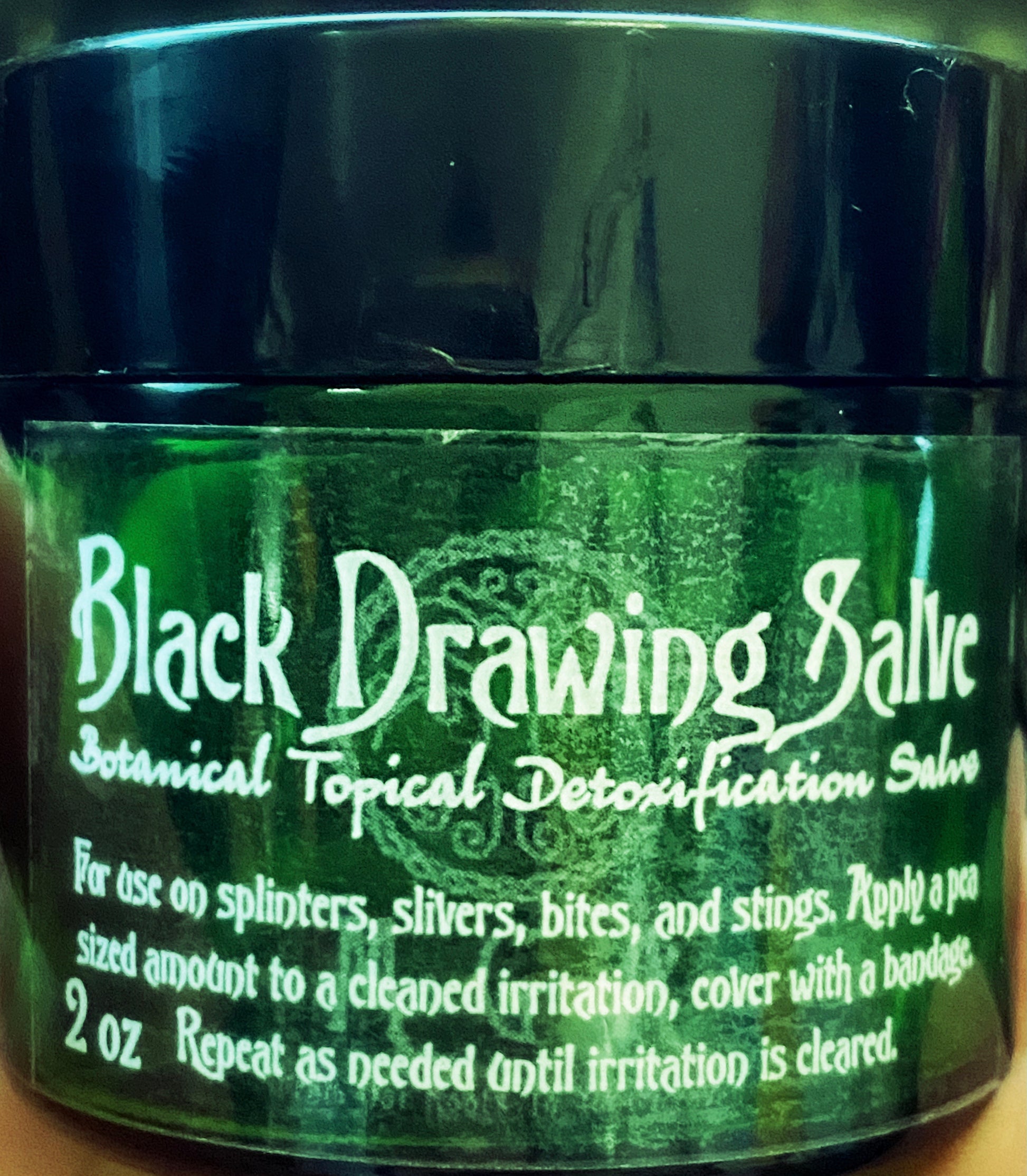 Black Drawing Salve, the tin opened to show the balm