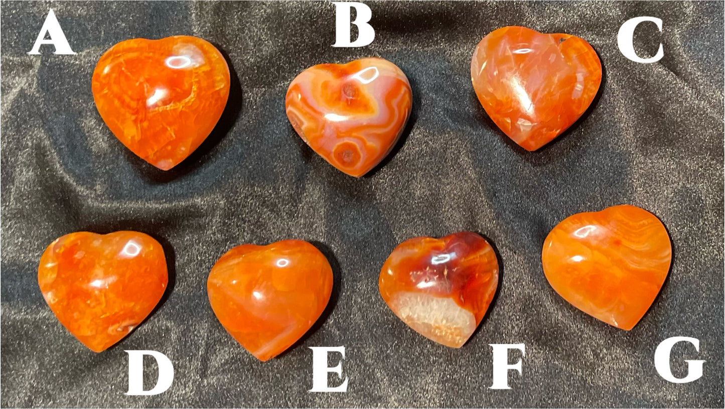 Carnelian crystal heart, held in hand for scale